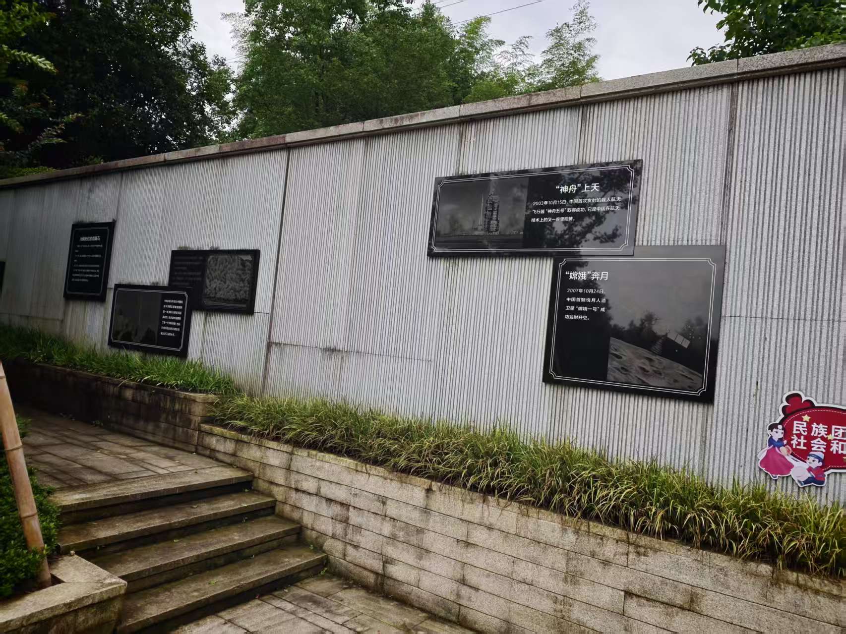沿白墙布置的文字展板与石铺步道